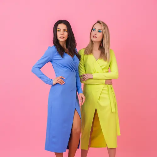 two-stylish-sexy-attractive-women-posing-full-height-pink-wall-stylish-colorful-dresses-blue-yellow-color-summer-fashion-trend